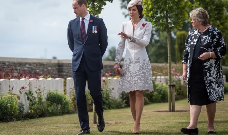 Kate Middleton (tengah) bersama suaminya Pangeran William (kiri). Kate kerap tampil anggun dalam balutan sepatu hak tinggi.