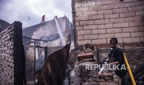 Kebakaran di Krukut Taman Sari. Petugas pemadam kebakaran bersama warga melakukan pendinginan pascakebakaran yang melanda permukiman padat penduduk di Jalan Ketapang Utara, Krukut, Tamansari, Jakarta, Selasa (26/2/2019).