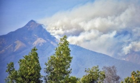 Kebakaran kawasan hutan pelawangan Senaru Gunung Rinjani terlihat dari Desa Anyar, Kecamatan Bayan, Lombok Utara, NTB, Minggu (20/10/2019). Kebakaran hutan pelawangan Senaru tersebut terjadi sejak tiga hari lalu yang diduga terjadi akibat kemarau panjang dan berdampak pada terjadinya kebakaran hutan. 