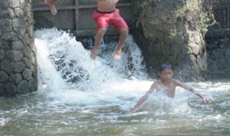 Keceriaan para bocah ketika bermain air terlihat di saluran irigasi di kawasan Neglasari, Tangerang, Banten, Rabu (14/9). Bermain air menjadi cara mereka untuk mengusir panasnya selama kemarau. (Republika/Aditya)