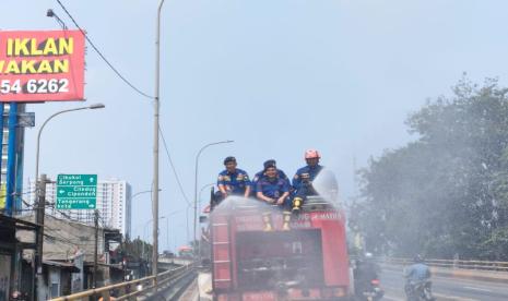 Kegiatan penyemprotan air di jalan protokol yang dilakukan BPBD Kota Tangerang untuk menekan polusi udara. 