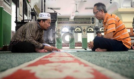 Ketua Lembaga Tahfizh Al-Azhar, Achmad Khotib (kiri) membimbing jamaah peserta Program Hafalan Alquran di Masjid Al-Azhar, Jakarta, Ahad (9/6).  (Republika/Agung Supriyanto)  