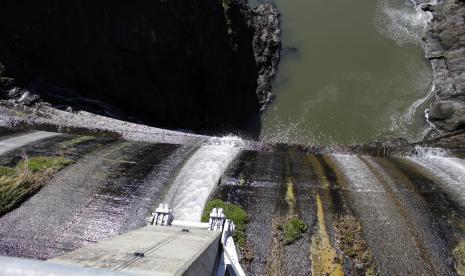 Kelebihan air tumpah di atas bendungan di Sungai Klamath Bawah yang dikenal sebagai Copco 1 dekat Hornbrook, California, pada 3 Maret 2020. Rencana proyek penghancuran bendungan terbesar dalam sejarah AS untuk menyelamatkan salmon yang terancam punah dapat segera menjadi kenyataan, dengan tahap pertama konstruksi dimulai di California pada awal musim panas ini. Komisi Regulasi Energi Federal bertemu Kamis, 17 November 2022, dan diharapkan untuk memberikan suara apakah akan menyetujui penyerahan lisensi pembangkit listrik tenaga air PacificCorp untuk empat bendungan di hilir Sungai Klamath di California utara yang terpencil.