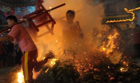 Kelompok kesenian melompati kobaan api saat malam puncak perayaan Cap Go Meh