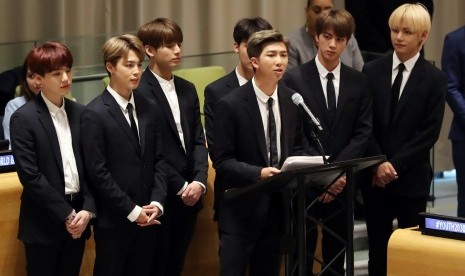 Kelompok musik Korea BTS dengan RM berdiri di podium.