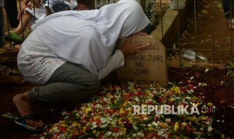 Keluarga Almarhum Damanhuri Zuhri mencium pusara usai pemakaman di Parung, Bogor, Jawa Barat, Senin (2/1). Kang Daman meninggal akibat penyakit pada Senin (2/1) pagi. 