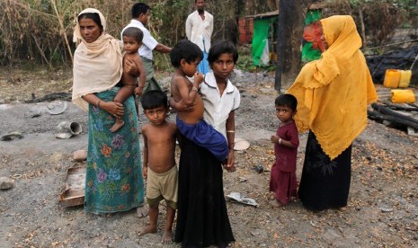 Keluarga dari etnis Rohingya berdiri di dekat pasar yang dibakar, di desa Rohingya luar Maungdaw, di negara bagian Rakhine, Myanmar 27 Oktober 2016. Gambar diambil tanggal 27 Oktober 2016.