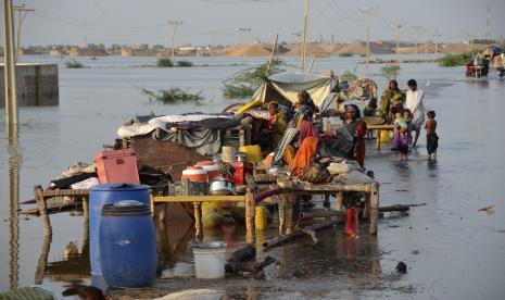  Keluarga duduk di dekat barang-barang mereka yang dikelilingi oleh air banjir, di kota Sohbat Pur di Jaffarabad, sebuah distrik di provinsi Baluchistan barat daya Pakistan, Ahad, 28 Agustus 2022. Menteri Luar Negeri Pakistan Bilawal Bhutto-Zardari mengatakan dampak ekonomi banjir masih diasesmen tapi diperkirakan sekitar 4 miliar dolar AS.