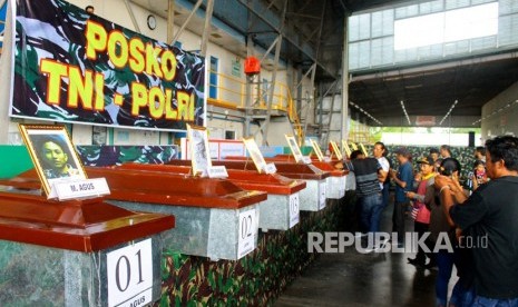 Keluarga korban berada di dekat peti berisi jenazah korban penembakan kelompok kriminal bersenjata (KKB) saat diserahterimakan di hanggar Avco Bandara Moses Kilangin Timika, Mimika, Papua, Jumat (7/12/2018). Pada Senin (30/12), kontak bersenjata kembali terjadi dan menewaskan seorang prajurit TNI di Keerom, Papua.