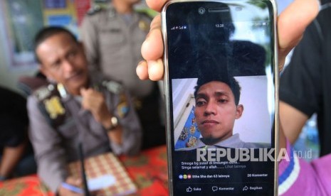 Keluarga korban kapal tenggelam KM Sinar Bangun menunjukkan foto anggota keluarganya yang merupakan penumpang hilang bernama Sarsubhan alias Yusuf, di posko Pelabuhan Tigaras, Simalungun, Sumatera Utara, Rabu (20/6).