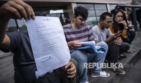 Keluarga korban kecelakaan penerbangan Lion Air PK - LQP nomor penerbangan JT 610 menunjukkan surat keterangan dari Lion Air kepada wartawan di halaman Hotel Ibis, Cawang, Jakarta, Rabu (23/1/2019). 