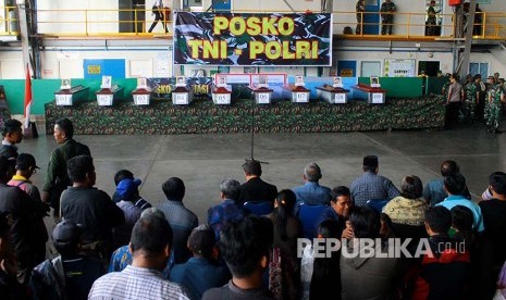 Keluarga korban mengikuti serah terima jenazah korban penembakan kelompok kriminal bersenjata (KKB) di hanggar Avco Bandara Moses Kilangin Timika, Mimika, Papua, Jumat (7/12)