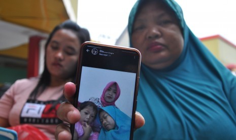 Keluarga korban menunjukkan foto Yunita Sari (30) dan kedua anaknya Farisa (10) dan Runisa Syakila (2) yang menjadi korban kebakaran pabrik korek api saat menunggu proses identifikasi jenazah di Rumah Sakit Bhayangkara Polda Sumut, di Medan, Sumatera Utara, Jumat (21/6/2019).