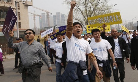  Keluarga korban penumpang pesawat Malaysia Airlines MH370  berunjuk rasa di depan gedung Kedubes Malaysia di Beijing, Selasa (25/3).   (Reuters/Kim Kyung-Hoon)