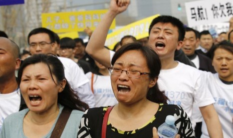  Keluarga korban penumpang pesawat Malaysia Airlines MH370  berunjuk rasa di depan gedung Kedubes Malaysia di Beijing, Selasa (25/3).   (Reuters/Kim Kyung-Hoon)