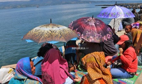 Keluarga korban tenggelamnnya KM Sinar Bangun menunggu di dermaga Pelabuhan Tigaras, Danau Toba, Simalungun, Sumatera Utara, Jumat (22/6).