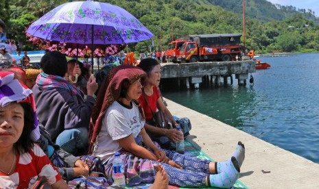 Keluarga korban tenggelamnnya KM Sinar Bangun menunggu di dermaga Pelabuhan Tigaras, Danau Toba, Simalungun, Sumatera Utara, Jumat (22/6).