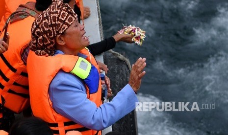 Keluarga korban tenggelamnya KM Sinar Bangun memanjatkan doa dalam prosesi tabur bunga di kawasan titik tenggelamnya kapal di Danau Toba, Sumatera Utara, Senin (2/7). 