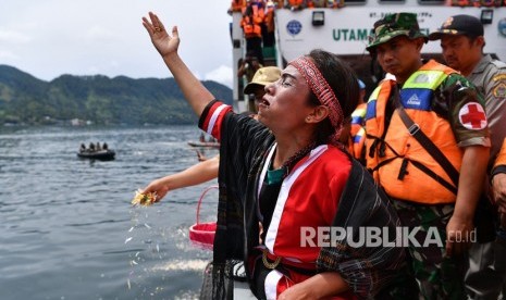 Keluarga korban tenggelamnya KM Sinar Bangun memanjatkan doa dalam prosesi tabur bunga di kawasan titik tenggelamnya kapal di Danau Toba, Sumatera Utara, Senin (2/7). 