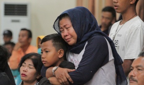 Keluarga korban tenggelamnya KM Sinar Bangun menangis saat mendengar penjelasan Basarnas di kantor Bupati Simalungun, Sumatera Utara, Minggu (1/7).