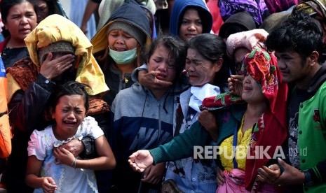 Keluarga korban tenggelamnya KM Sinar Bangun menangis saat tabur bunga di Dermaga Tigaras, Danau Toba, Simalungun, Sumatera Utara, Selasa (3/7).