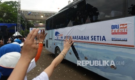 Keluarga melambaikan tangan kepada pemudik yang mengikuti mudik bareng dengan tema Nge-Buzz Bareng BRI di Senayan, Jakarta, Rabu (29/6). (Republika/Raisan Al Farisi)