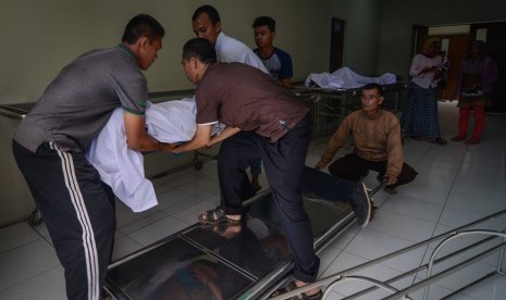 Keluarga memindahkan jenazah korban meninggal akibat keracunan minuman keras (miras) oplosan ke dalam mobil ambulans di Rumah Sakit Umum Daerah (RSUD) Cicalengka, Kabupaten Bandung, Jawa Barat, Senin (9/4). 