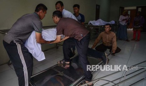 Keluarga memindahkan jenazah korban meninggal akibat keracunan minuman keras (miras) oplosan ke dalam mobil ambulans di Rumah Sakit Umum Daerah (RSUD) Cicalengka, Kabupaten Bandung, Jawa Barat, Senin (9/4). 