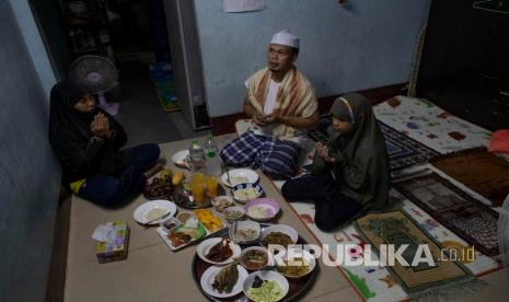 Keluarga Muslim Thailand berdoa sebelum berbuka puasa di ruang tamu rumah mereka di Bangkok, Thailand, Selasa (28/4). Sebagian besar tempat ibadah, termasuk masjid ditutup untuk membantu mengurangi penyebaran virus corona ketika umat Islam di seluruh dunia mulai menjalani bulan suci Ramadhan saat masa lockdown yang belum pernah terjadi sebelumnya. 