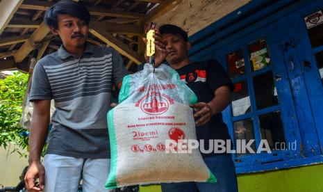 Keluarga Penerima Manfaat (KPM) menimbang kembali beras bansos Bantuan Pangan Non-Tunai (BPNT) di Lingkungan Citapen, Kelurahan Kertasari, Kabupaten Ciamis, Jawa Barat, Rabu (11/1/2022). Sejumlah KPM hanya menerima bantuan beras sebanyak 11 kilogram dari yang seharusnya 12 kilogram dan mereka menjualnya ke pasar dengan harga Rp7 ribu per kilogram karena tidak layak dikonsumsi.