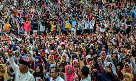 Keluarga Penerima Manfaat (KPM) menyanyikan mars Program Bantuan Harapan (PKH) saat acara Penyaluran Bantuan Sosial PKH dan Penyaluran Bantuan Pangan Non Tunai (BPNT) di Gor Dadaha, Kota Tasikmalaya, Jawa Barat, Kamis (11/4/2019).