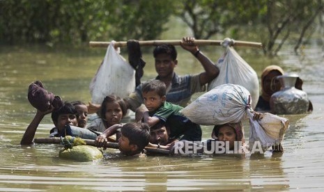 Keluarga pengungsi Rohingya melintasi sungai kecil di perbatasan Myanmar-Bangladesh near Cox's Bazar, Bangladesh, Selasa (5/9)