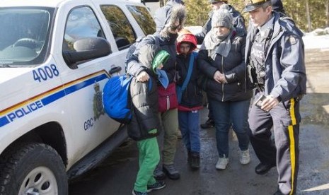 Keluarga pengungsi tiba di perbatasan Kanada dari Amerika Serikat dekat Hemmingford, Quebec, Senin, 20 Februari 2017.