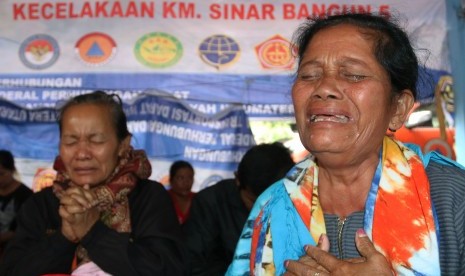 Family members of MV Sinar Bangun victims pray at Tigaras port, Lake Toba, Simalungun, North Sumatra, Monday (June 25).