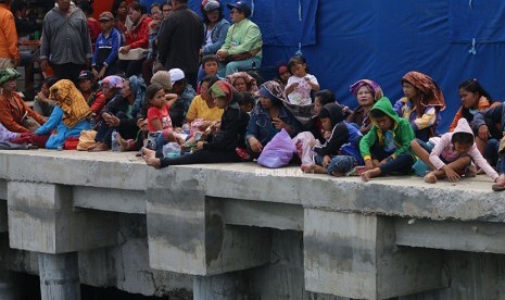 Keluarga penumpang KM Sinar Bangun duduk di dermaga Pelabuhan Tigaras, Danau Toba, Simalungun, Sumatera Utara, Kamis (21/6).