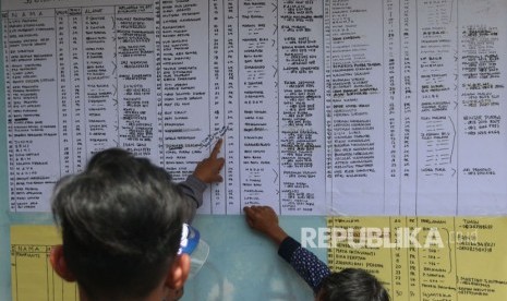 Keluarga penumpang KM Sinar Bangun melihat daftar nama korban yang hilang, di posko Pelabuhan Tigaras, Simalungun, Sumatera Utara, Rabu (20/6). 