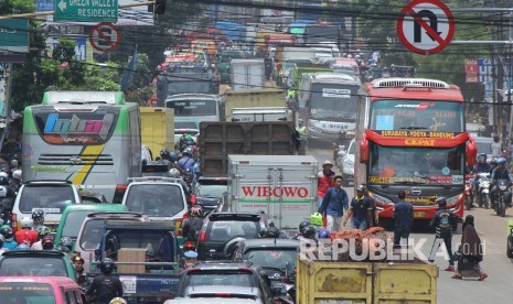 Kemacetan lalu lintas cukup parah saat proses pembersihan jalan yang dipenuhi lumpur dan sampah akibat banjir bandang di Cicaheum, Kota Bandung, Rabu (21/3).