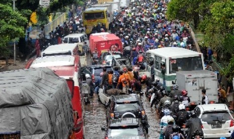 Kendaraan bermotor lawan arah menggunakan lajur kiri untuk menghindari banjir di Jalan Daan Mogot, Jakarta Barat, Selasa (4/2). Kemacetan parah menjadi keseharian di jalan penghubung utama Jakarta-Tangerang setiap banjir. 