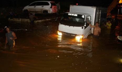 Kendaraan berusaha menerobos banjir yang menggenangi jalan trans Sulawesi penghubung Sulawesi Tenggara-Sulawesi Selatan di Desa Andadowi, Konawe, Sulawesi Tenggara, Selasa (12/6/2019).