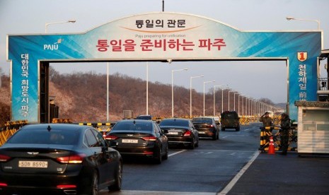 Kendaraan delegasi Korea Selatan yang dipimpin Menteri Unifikasi Korsel Cho Myoung-gyon melewati pos pemeriksaan di Jembatan Unifikasi Agung yang menuju ke Panmunjom di selatan zona demiliterisasi di Paju, Korsel, Selasa (9/1).