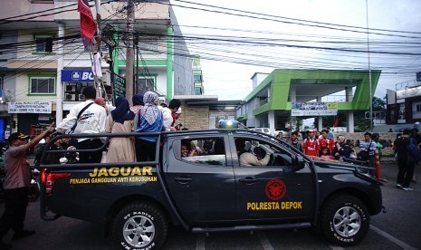 KRL Anjlok. Kendaraan kepolisian Kota Depok mengangkut penumpang yang terlantar di jalan Kartini Pancoran Mas Depok, Jawa Barat, Ahad (10/3/2019). 