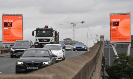 Kendaraan melintas di dekat Canary Wharf, London, Inggris, 17 October 2020. Penjualan mobil baru di Inggris merosot akibat pembatasan mobilitas untuk mengendalikan pandemi Covid-19.