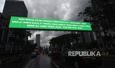 Kendaraan melintas di dekat papan informasi kebijakan sistem pembatasan kendaraan bermotor berdasarkan nomor plat ganjil-genap di kawasan Sudirman, Jakarta, Kamis (21/3/2019).