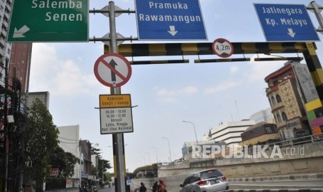 Kendaraan melintas di dekat rambu pembatasan kendaraan ganjil genap yang terpasang di kawasan Matraman di Jakarta, Ahad (8/9/2019). 