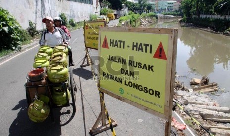  Kendaraan melintas di jalan Inspeksi Ciliwung Lama yang longsor, Jakarta Pusat, Selasa (19/11).  (Republika/Yasin Habibi)