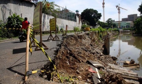  Kendaraan melintas di jalan Inspeksi Ciliwung Lama yang longsor, Jakarta Pusat, Selasa (19/11).  (Republika/Yasin Habibi)