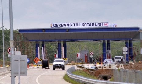 Kendaraan melintas di lokasi pembangunan pintu keluar Jalan Tol Trans Sumatera (JTTS) Seksi II Ruas Sidomulyo-Kota Baru di Desa Sabah Balau, Lampung Selatan, Lampung, Senin (18/12). 