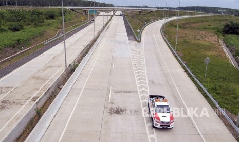 Kendaraan melintas di lokasi pembangunan pintu keluar Jalan Tol Trans Sumatera (JTTS) Seksi II Ruas Sidomulyo-Kota Baru di Desa Sabah Balau, Lampung Selatan, Lampung, Senin (18/12). 