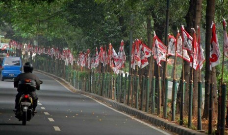 Kendaraan melintas di samping alat peraga kampanye salah satu calon pasangan presiden dan wakil presiden di Kawasan Menteng, Jakarta Pusat, Senin (23/6).