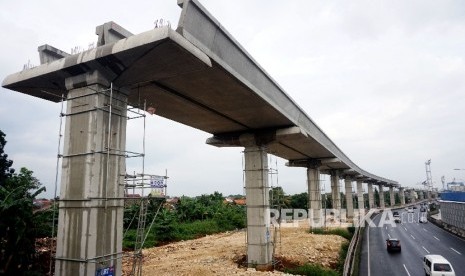 Kendaraan melintas di samping proyek infrastruktur transportasi massal kereta ringan atau Light Rail Transit (LRT) di kawasan Halim, Jakarta. ilustrasi